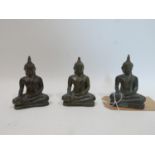 A set of three Tibetan bronze models of seated Buddha's, H.11cm