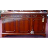 A Georgian style yew wood sideboard, with three drawers over three cupboard doors, raised on bracket