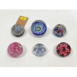 A collection of six glass paperweights, to include a Strathearn example with millefiori