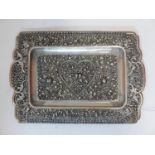 An Indian white metal tray, with intricate pierced decoration of flowers and scrolling foliage, with