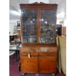 A Regency mahogany and boxwood inlaid secretaire bookcase, two glazed doors over fitted desk,