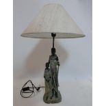 A contemporary figural resin table lamp with shade