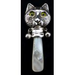 A sterling silver baby rattle in the form of a cat's head with glass eyes and a mother of pearl