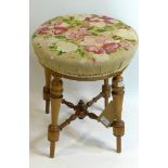 A Victorian walnut stool, floral embroidered, on turned supports and X-stretcher