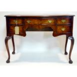 A Georgian style mahogany serpentine fronted desk, with five drawers, raised on cabriole legs, H.