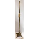 An adjustable brass standard lamp, raised on quadriform base and lion paw feet, H.158cm