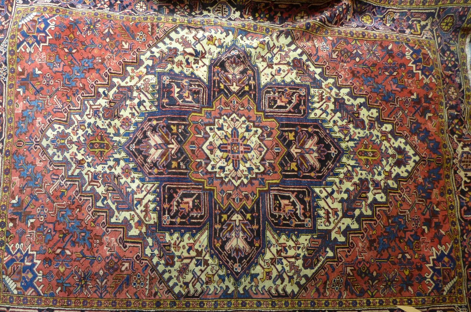 A North West Persian Heriz carpet, central diamond medallion with repeating petal motifs on a