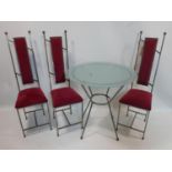 A contemporary wrought iron glass top table with three matching chairs