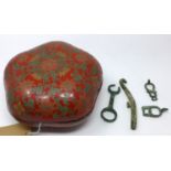 A red Chinese lacquered lidded pot 10 x 22cm containing 4 antiqued Chinese bronze implements.