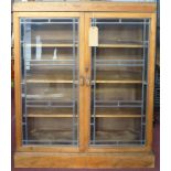 An early 20th century A.J. Whitehead Of Chatham oak bookcase, with leaded glass panel doors, H.108