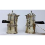 A pair of silver silver chocolate pots with side mounted handles, Goldsmiths & Silversmiths Co