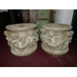 Two reconstituted stone pots, decorated with a procession of cherubs and floral swags, H.32cm