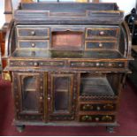 An early 20th century ebonised roll top bureau, hand painted with flowers, the roll top revealing