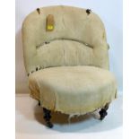A Victorian chair with turned ebonized legs and castors, in need of reupholstering
