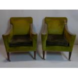 A pair of contemporary armchairs with green and grey velour upholstery and leather arm rests, raised