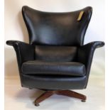 A 20th century wing back swivel chair in black vinyl
