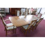 An Ercol dining table with two extra leaves, H: 74, W: 250, D: 101cm together with 6 matching dining