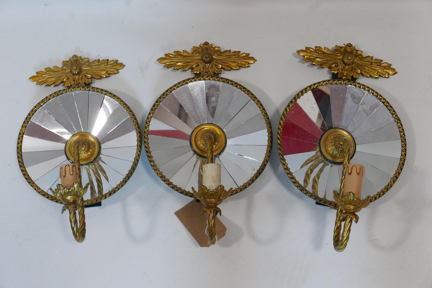 A set of three Empire style gilt metal wall lights with mirrored backs, H.45 W.26cm