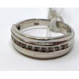 An 18ct white gold ring centrally channel-set with 11 round brilliant-cut diamonds, Size: J1/2, 3g.