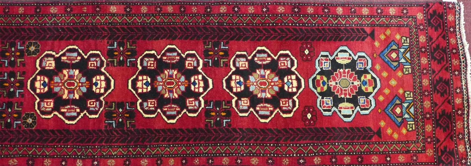 A North East Persian Kurdish runner, repeating pendent motifs with geometric motfis on a rouge - Image 4 of 5