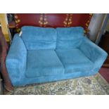 A contemporary sofa bed with blue corduroy upholstery