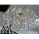 A contemporary cream metal 12 branch chandelier with glass droplets