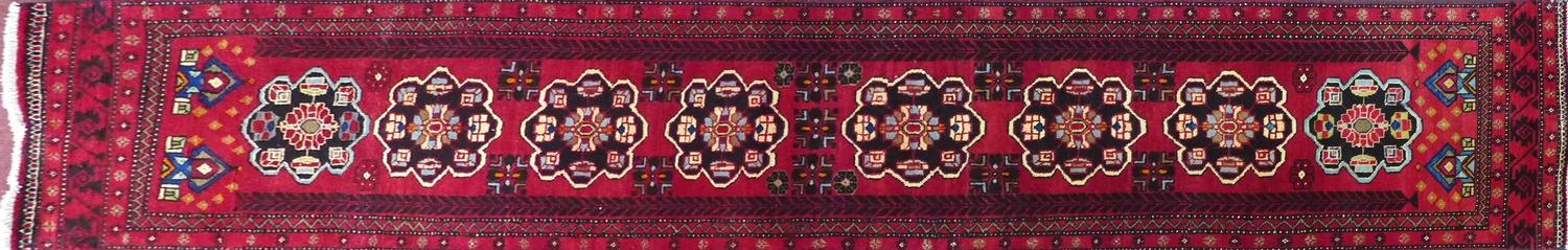 A North East Persian Kurdish runner, repeating pendent motifs with geometric motfis on a rouge - Image 2 of 5