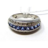 A 9ct white gold diamond and Ceylon sapphire ring, centrally set with a row of 9 princess-cut ceylon
