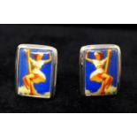 A pair of sterling silver cufflinks each set with a ceramic panel depicting a 1950s pin-up lady