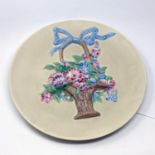 A Clarice Cliff charger, with high relief moulded basket of flowers, marked to reverse, Diameter