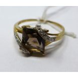 A 9ct yellow and white gold ring centrally set with a large princess-cut smokey quartz flanked