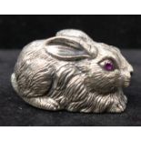 A miniature sterling silver figure of a rabbit inset with faceted ruby eyes