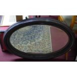 An early 20th century mahogany oval mirror with bevelled plate, 88 x 62cm