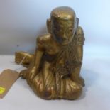 An early 20th century Chinese gilt hardwood carving of a kneeling monk, H.27cm