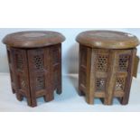 A pair of 20th century Nomad's tables, the round tops with brass inlay and floral carving, on