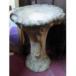 A stone bird bath in the form of a tree trunk, H.65cm