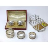 An early 20th century silver toast rack together with four silver napkin rings, 9oz, and one other