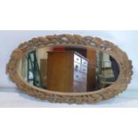 A large carved pine oval mirror, 135 x 75cm