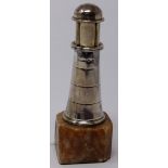 An early 20th century silver lighter in the form of a lighthouse, raised on alabaster base