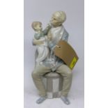 A Lladro figural study of a seated gentleman holding his grandchild, H.30cm