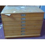 A 20th century light oak plan chest, with damaged top above seven long drawers, 67 x 98 x 65cm