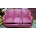 An Art Deco walnut sofa and matching pair of armchairs, with pink leather upholstery