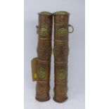 A pair of Tibetan repousse copper scroll holders both adorned with brass roundels depicting