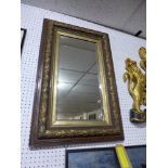 A 20th century wall mirror, with bevelled glass plate, the frame with gilt oak leaf decoration, 84 x
