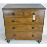 An early 19th century mahogany chest of two short over three long drawers, raised on turned feet,