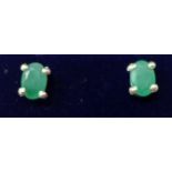 A boxed pair of sterling silver and faceted natural emerald stud earrings, 1g