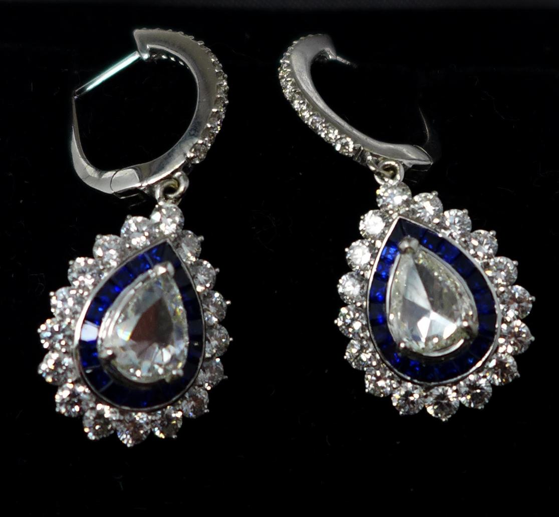 A boxed pair of 18ct white gold diamond and sapphire drop earrings, each earring centrally set