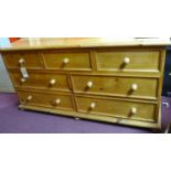 A 20th century long pine chest of 3 short over 4 long drawers, on bun feet, H.84 W.164 D.55cm