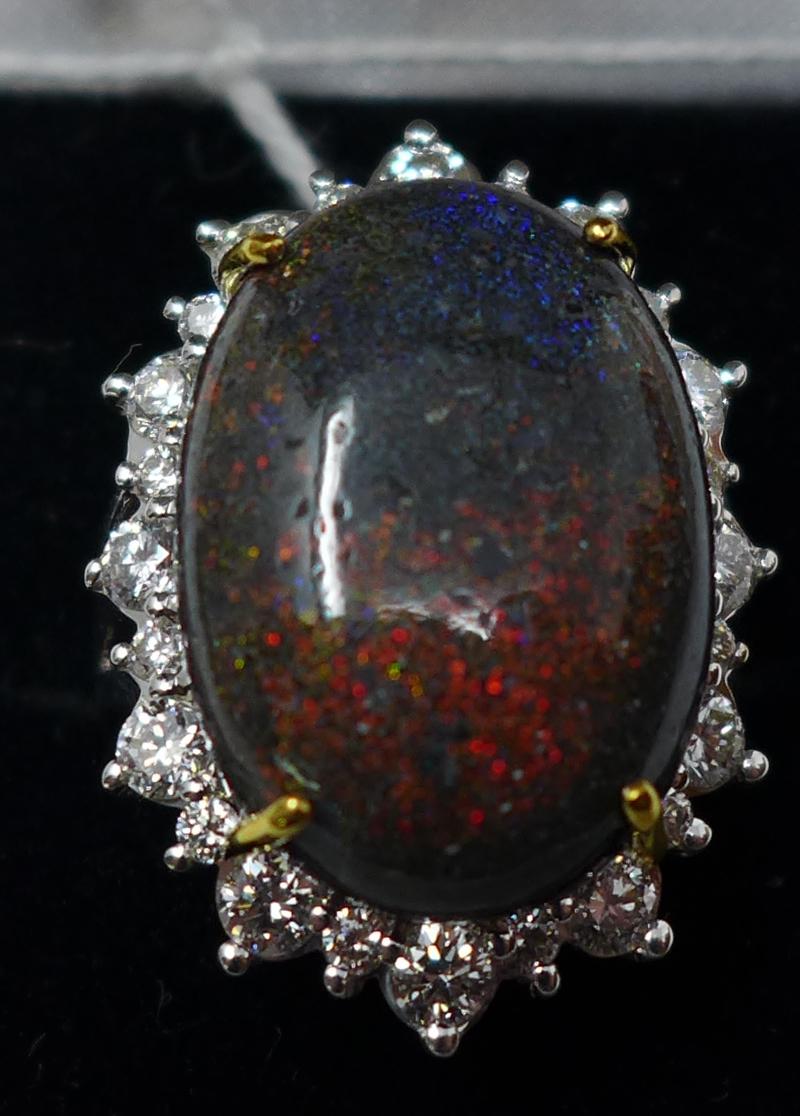 A boxed 18ct white gold natural black opal and brilliant-cut diamond ring, the central oval cabochon