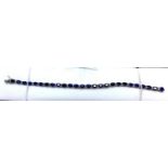 A boxed 18ct white gold sapphire and brilliant-cut diamond tennis bracelet composed of 26 oval